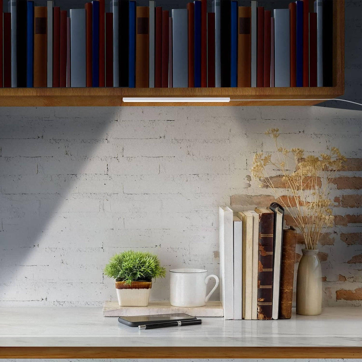 Slim white LED under-shelf light strip installed under cabinet, glowing