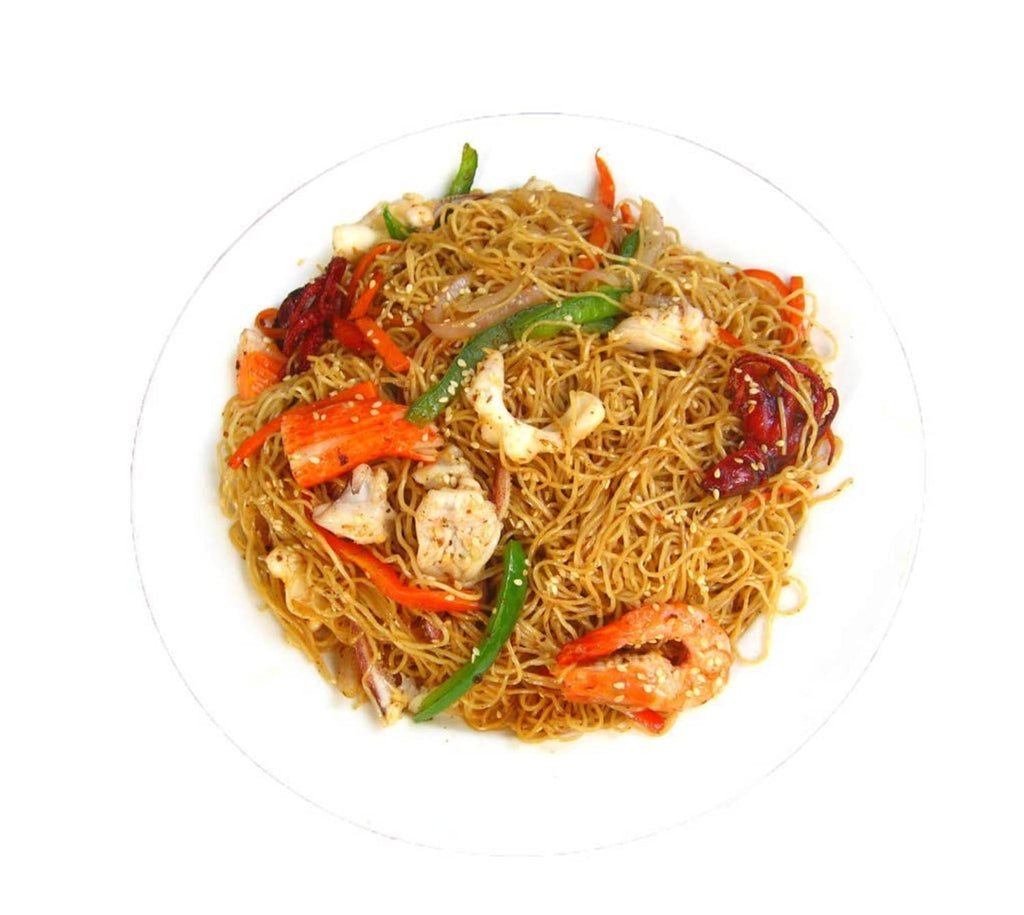 Served stir-fried noodles with chicken pieces, vegetables, and herbs on a plate