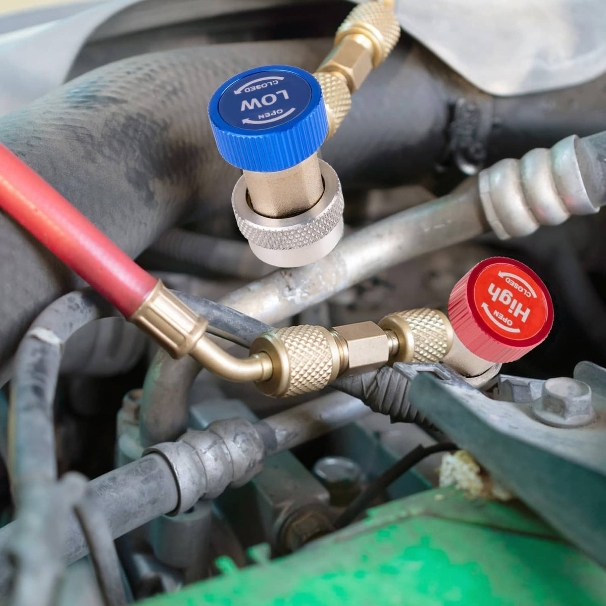 Refrigerant adapter fittings connected in an automotive engine compartment