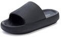 Black slip-on pillow slippers with wide textured strap and open toe.