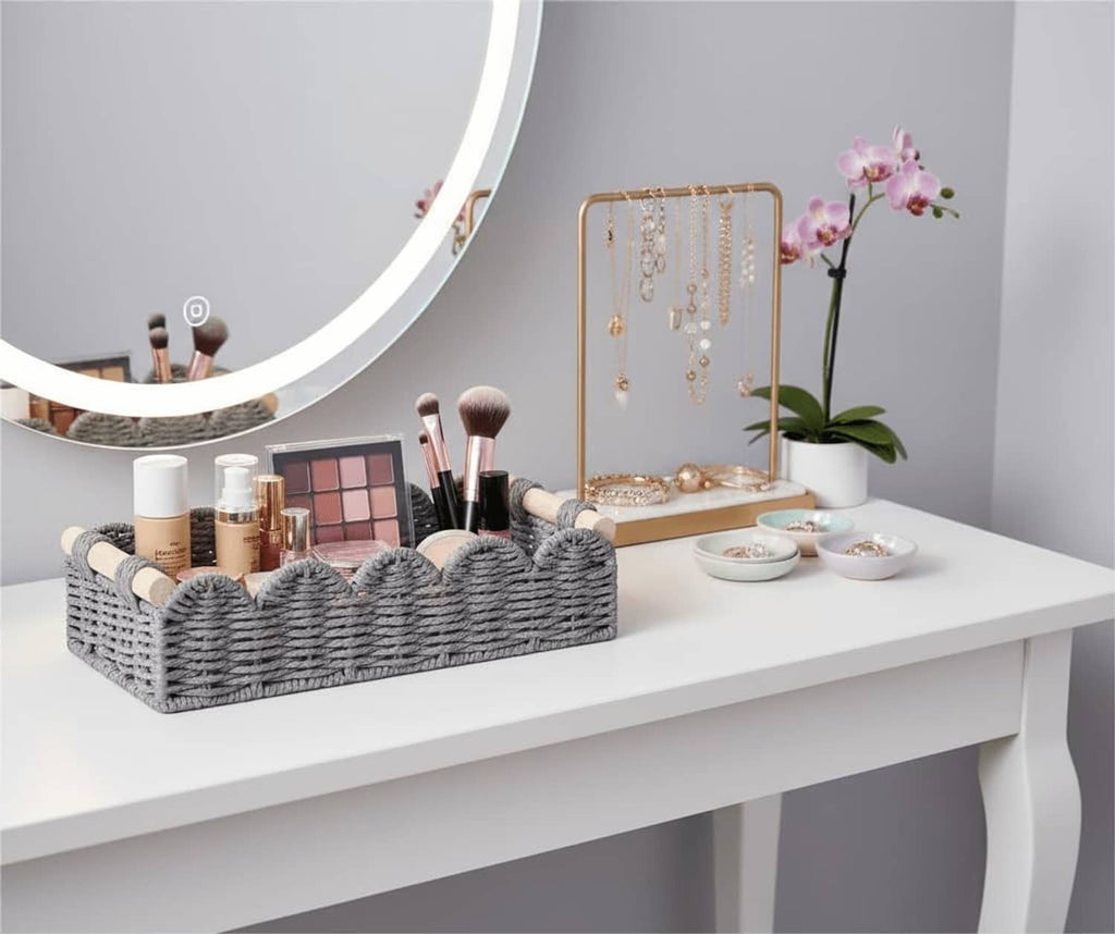 Grey woven rectangular toilet paper storage basket with scalloped open top and rope handle ends.