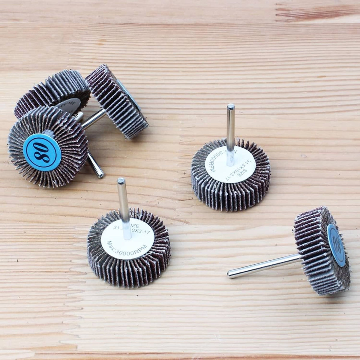 Flap sanding wheels with 80-grit discs and central metal shanks for drills