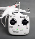Drone body with red/black decal markings on arms and front