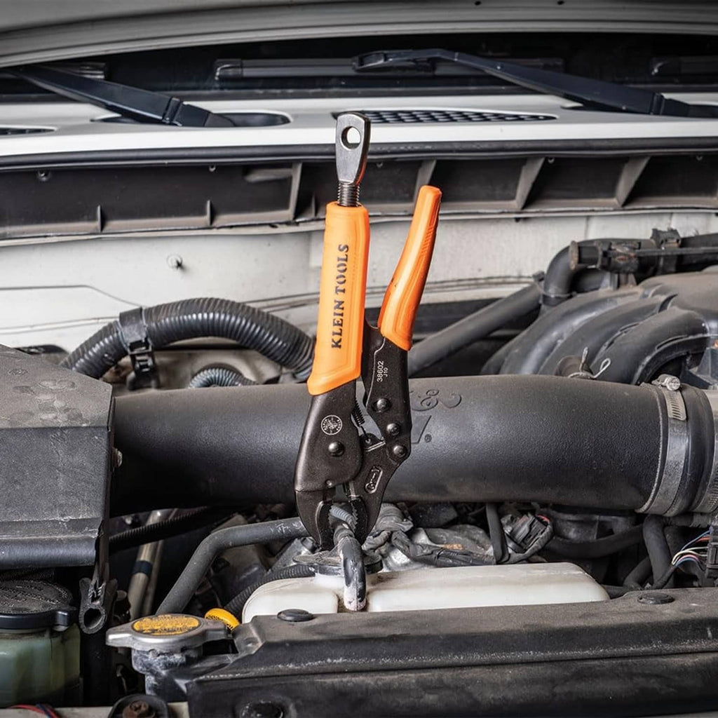 Orange-and-black locking pliers positioned in an engine compartment