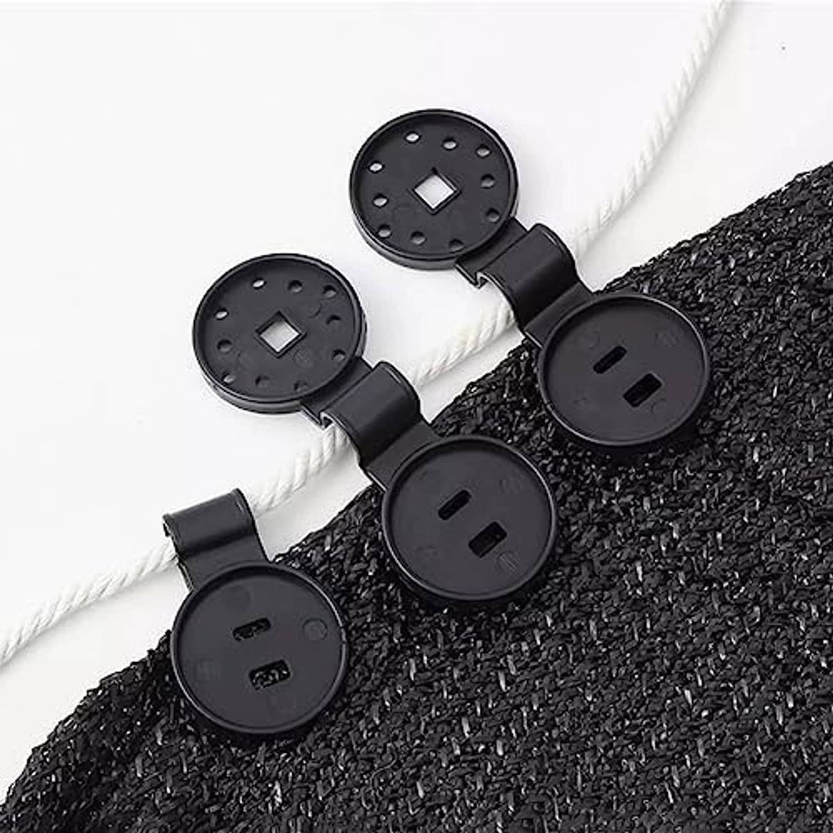 Black plastic net clips attached to thick rope along dark mesh fabric
