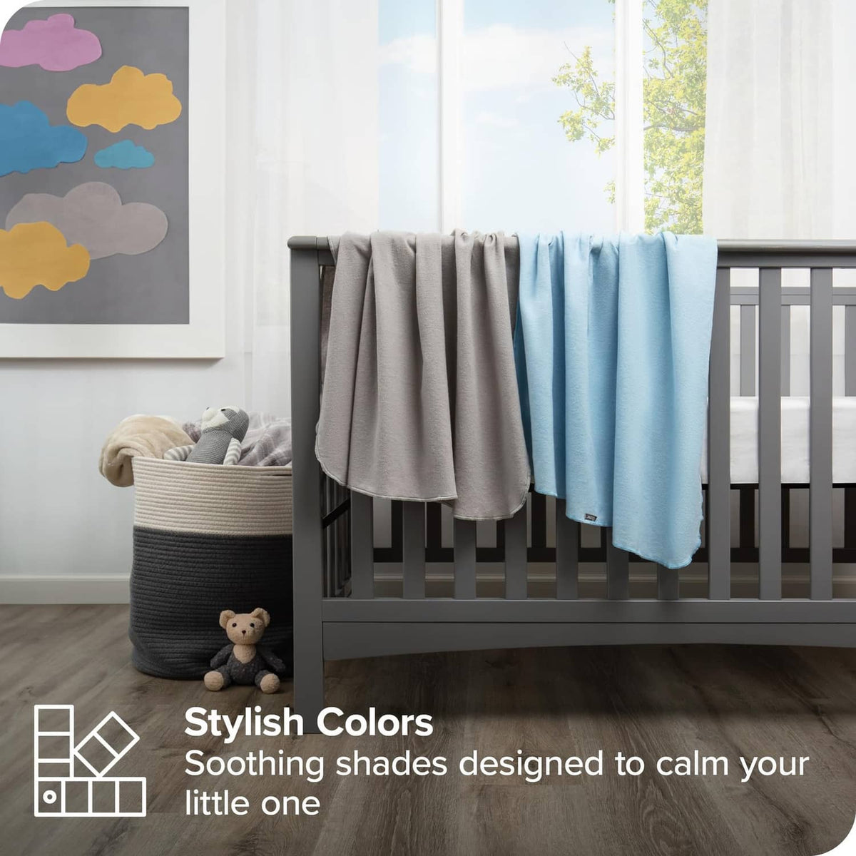 Baby crib blankets in gray and light blue draped over a crib rail