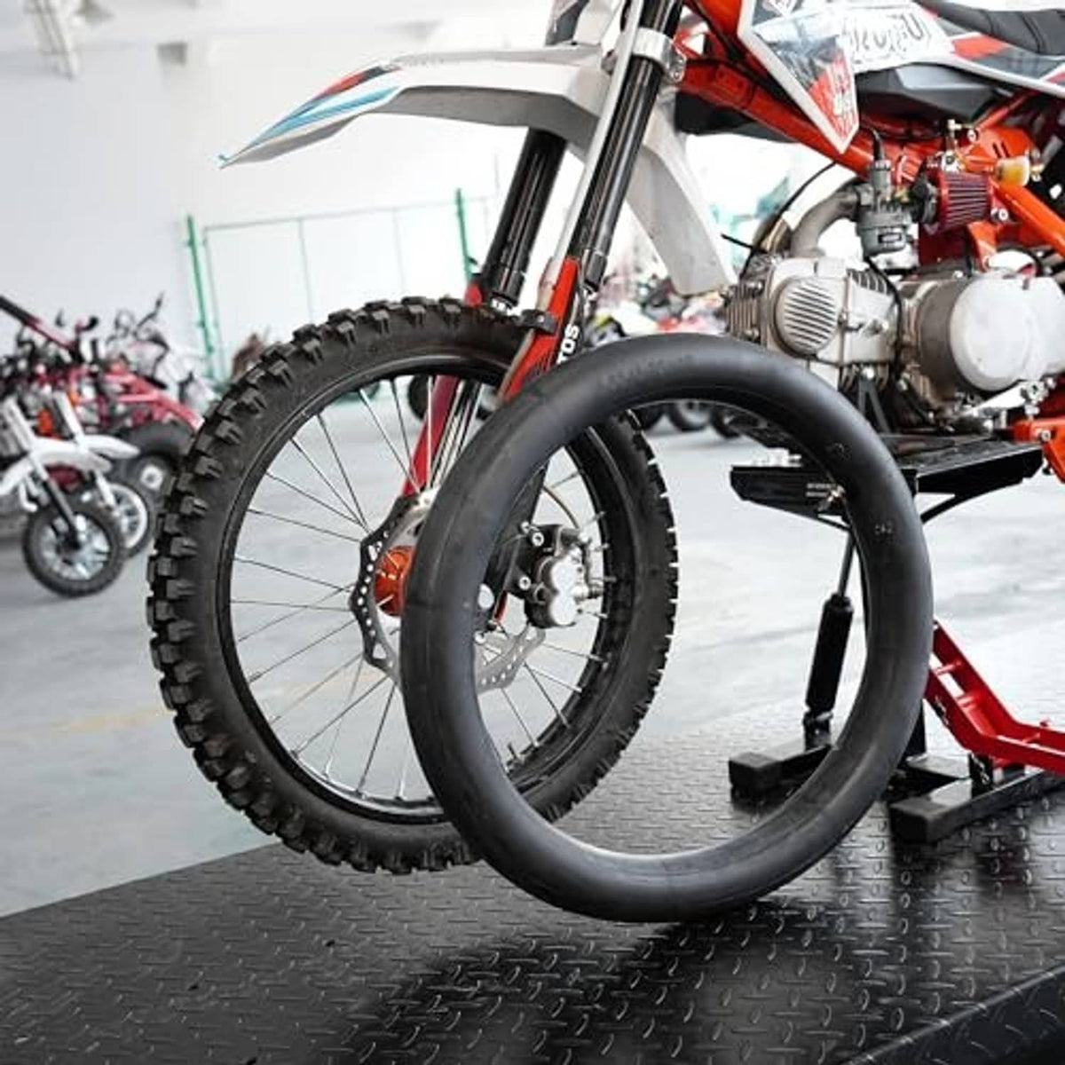 Black inner tube mounted on a dirt bike wheel, valve stem visible on the rim