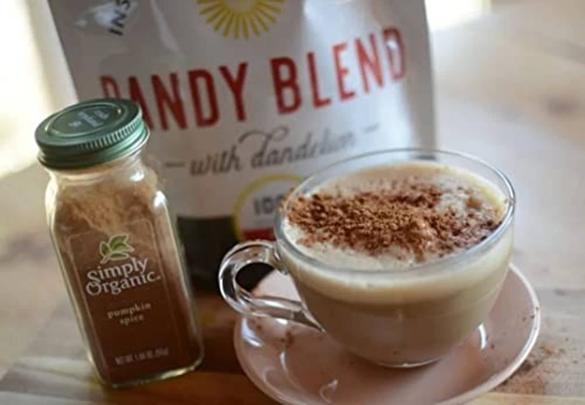 Instant herbal beverage mug with froth and a glass jar on table