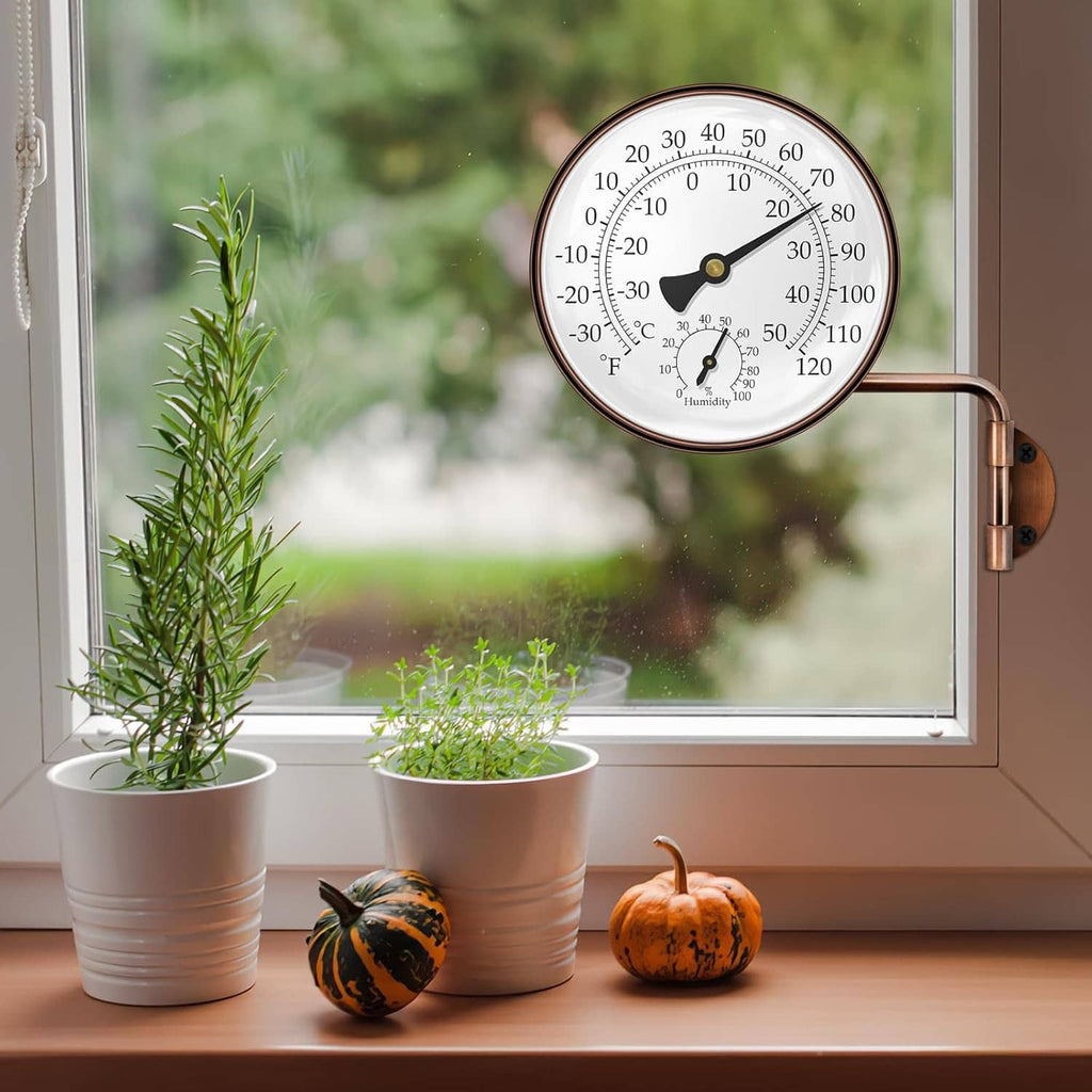 Brass swivel thermometer hygrometer mounted by a window, round dial with C/F and humidity