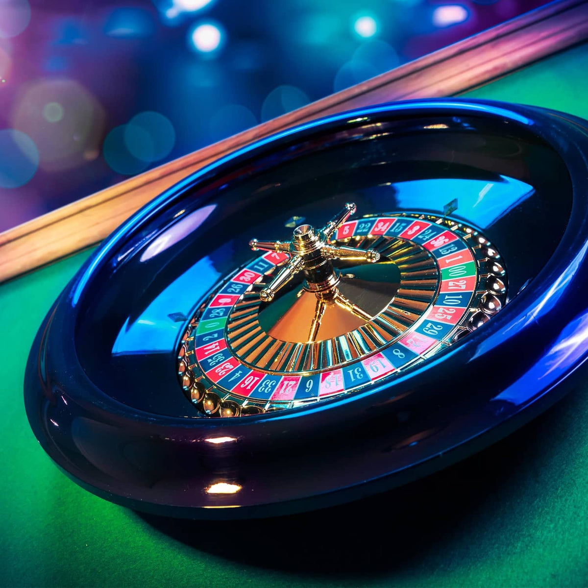 Glowing casino roulette wheel with gold spindle inside glossy black housing