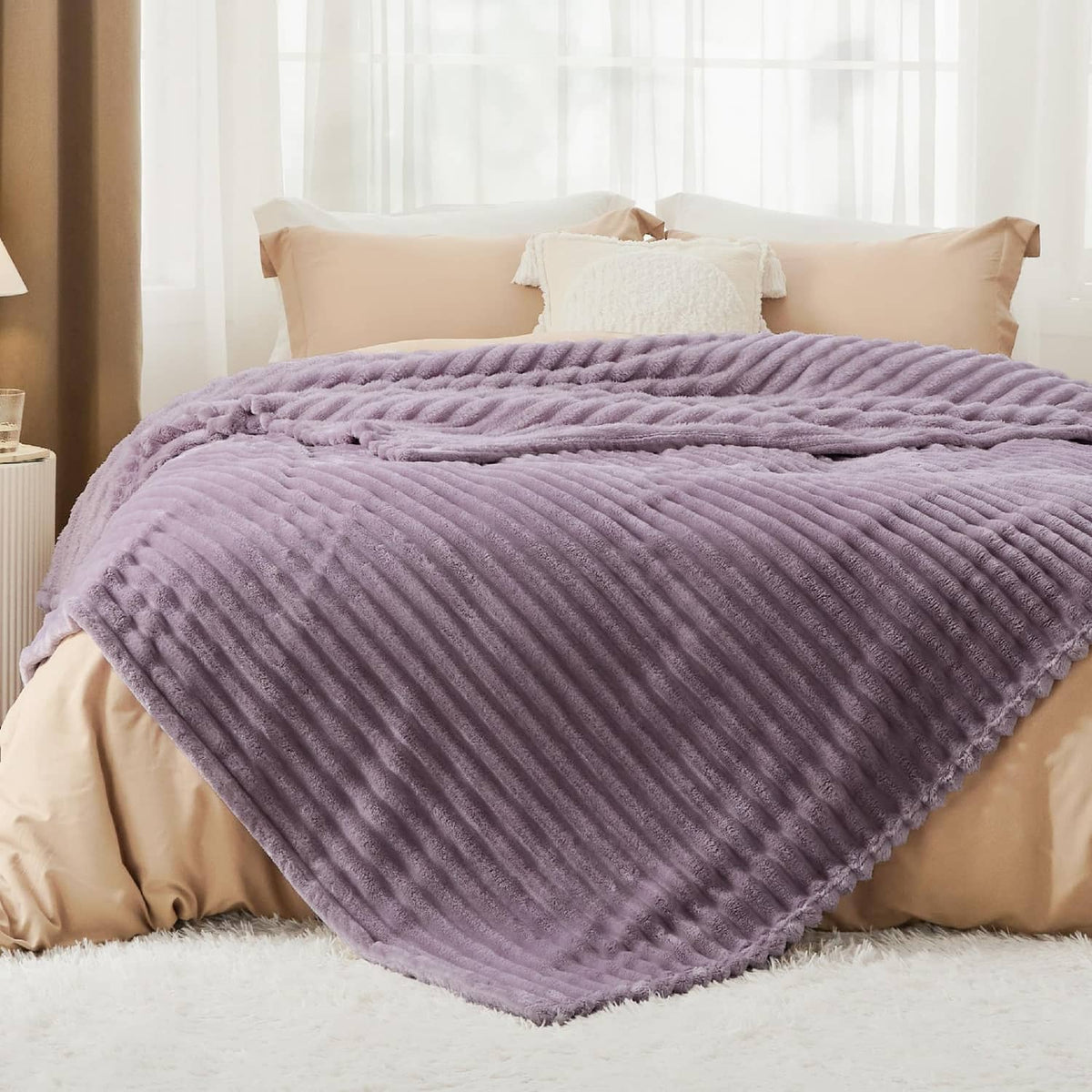 Lavender ribbed fleece throw blanket draped across a bed