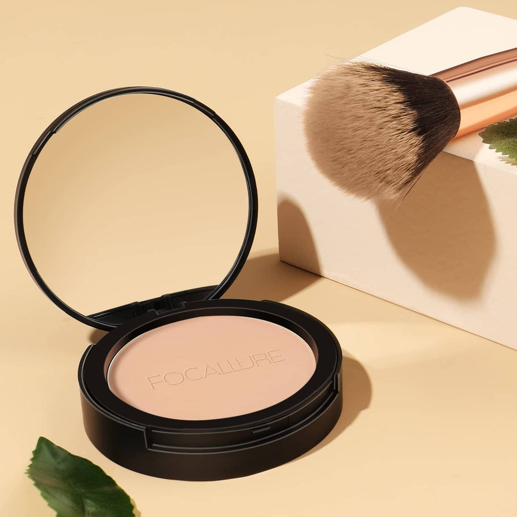 Black pressed powder compact with beige pan and makeup brush