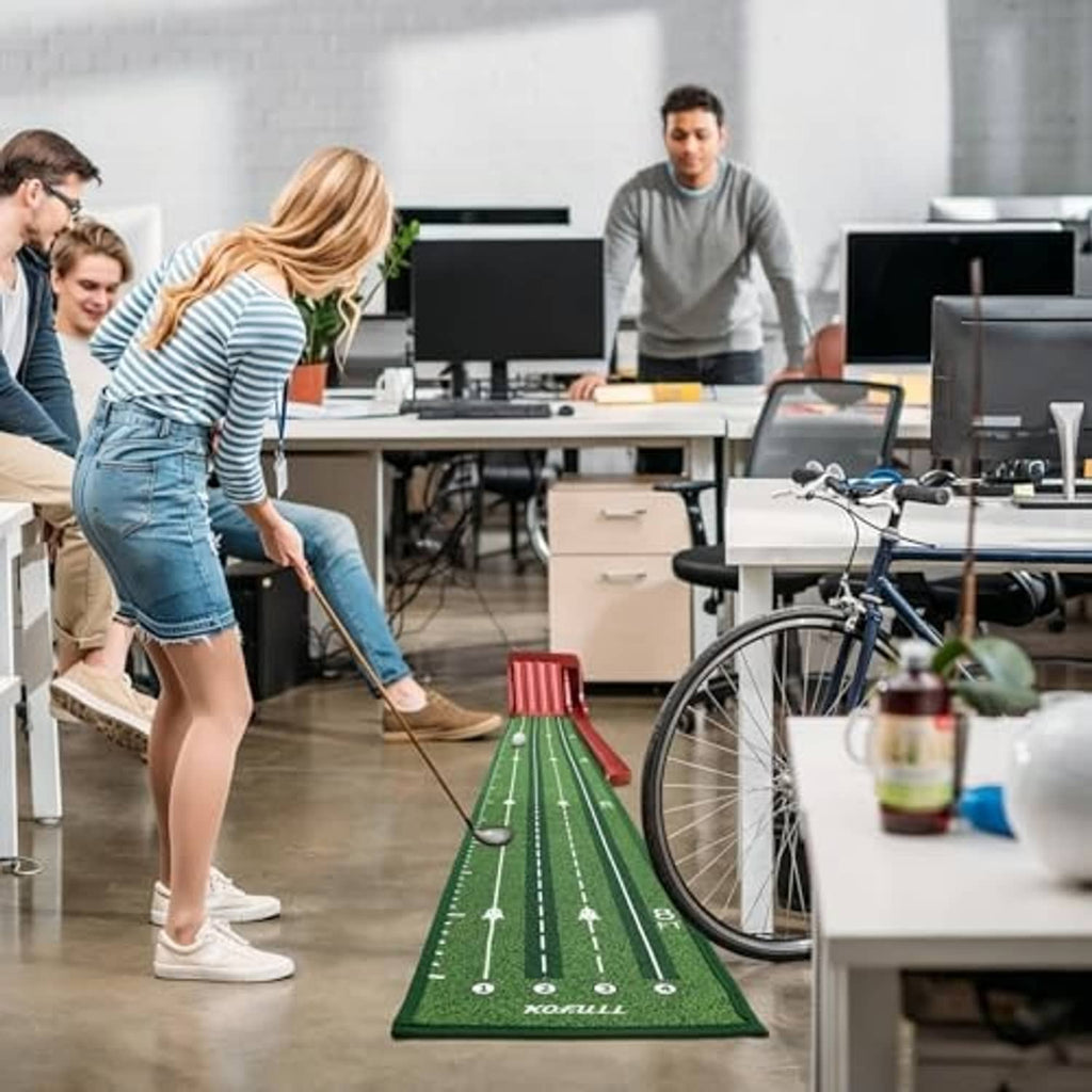 Green golf putting mat with red flip-ramp auto return in office setting