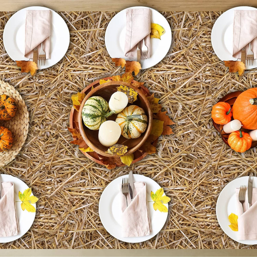 Brown straw table cover with white plates and napkins arranged across woven hay
