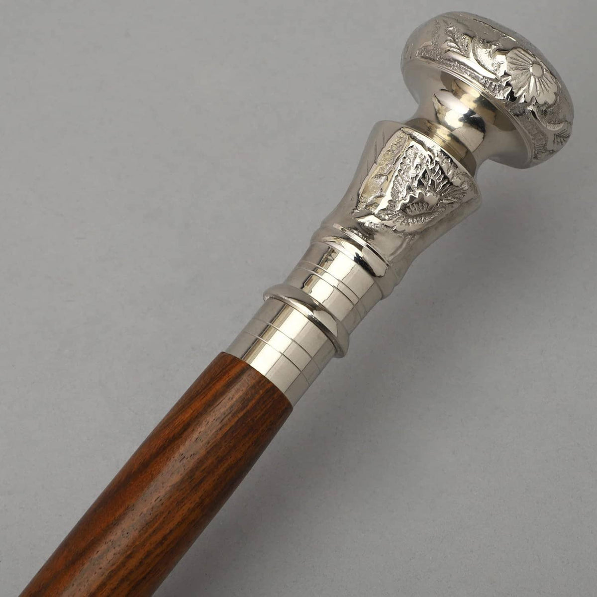 Brown wooden walking cane with silver decorative handle and curved top