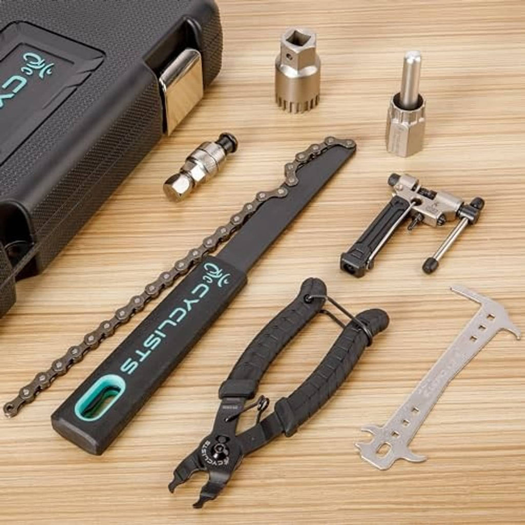Bike chain tools and cassette tools laid out on a wooden surface