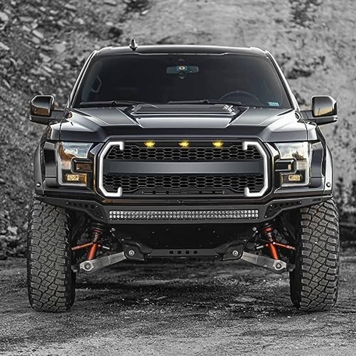 Front grille on pickup truck with black mesh and amber LED light bars, centered view