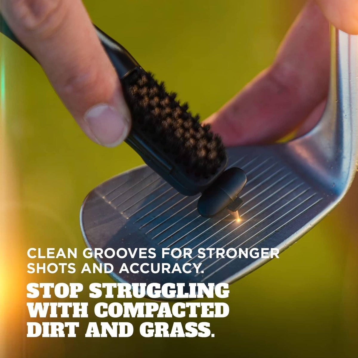 Close-up of the golf club cleaner bristles scrubbing grooves on a metal club face