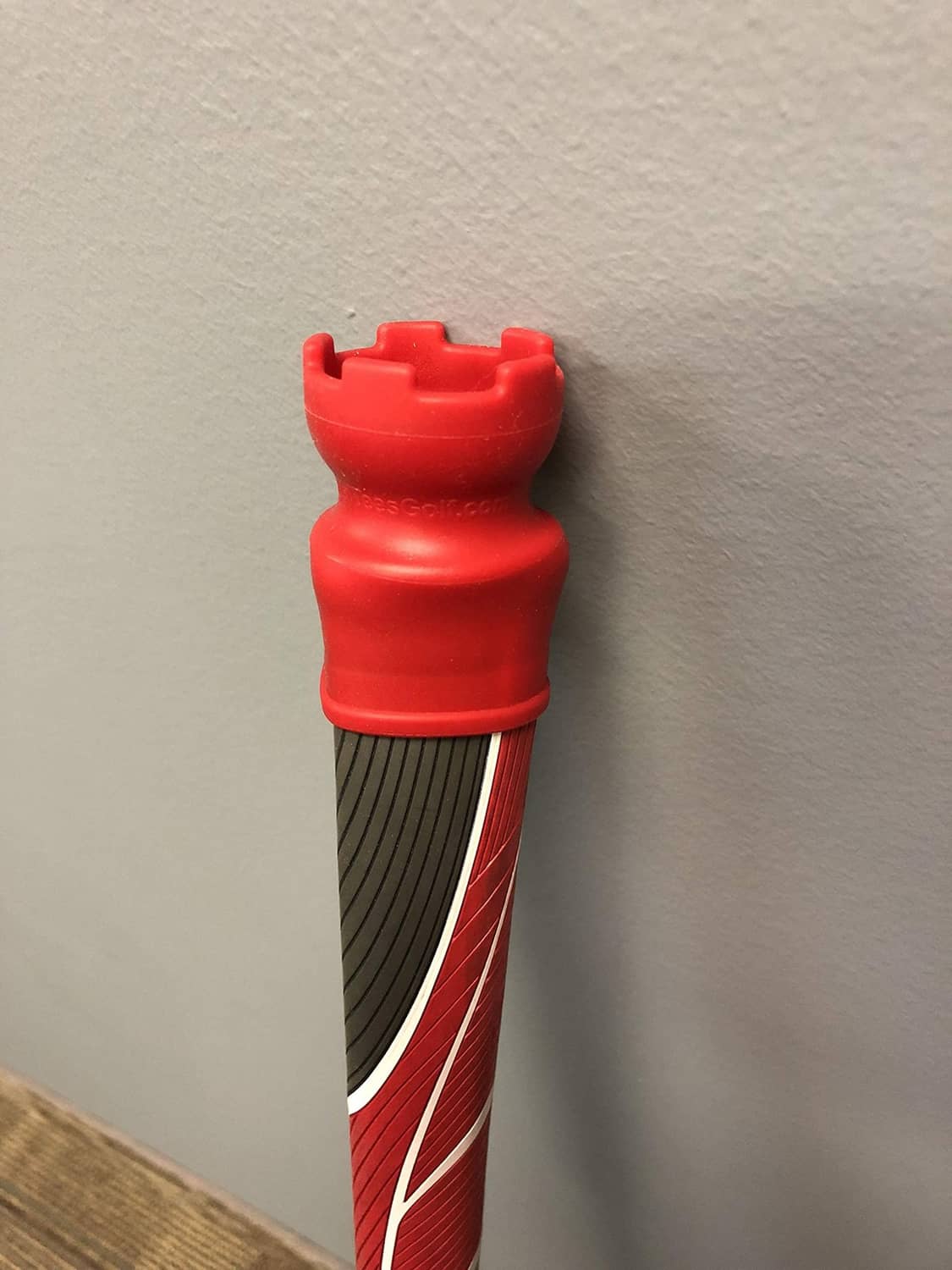 Red ball retriever with black ridged handle and red curved stripes