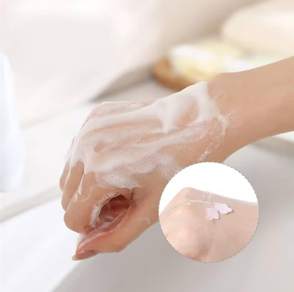 Person washing hands with petal-shaped soap paper, showing mild suds