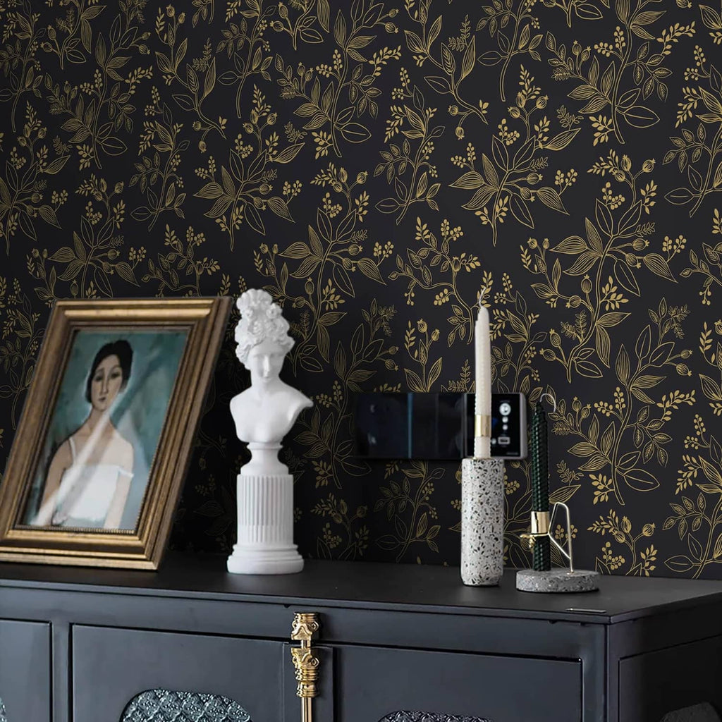 Black and gold botanical wallpaper covering the wall behind console decor