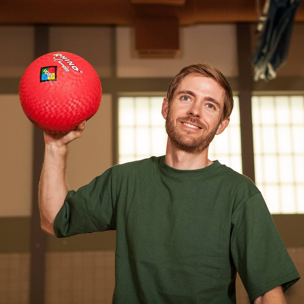 Red 10-inch playground ball held overhead, with PG10 logo on textured surface