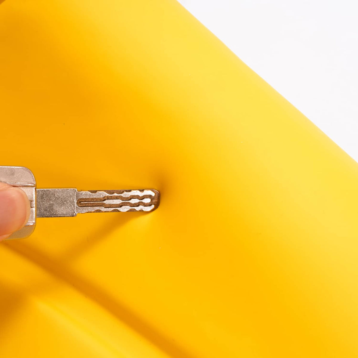Tool tightening a fastener on a yellow plastic seat panel