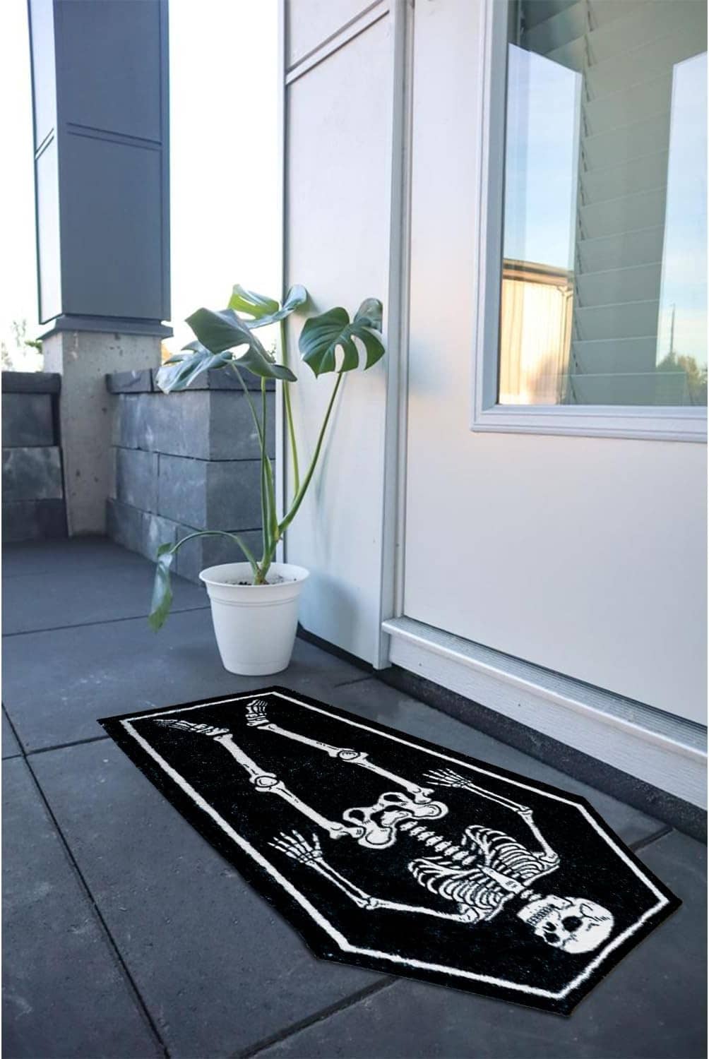 Rectangular black bath mat with white coffin skeleton bones graphic