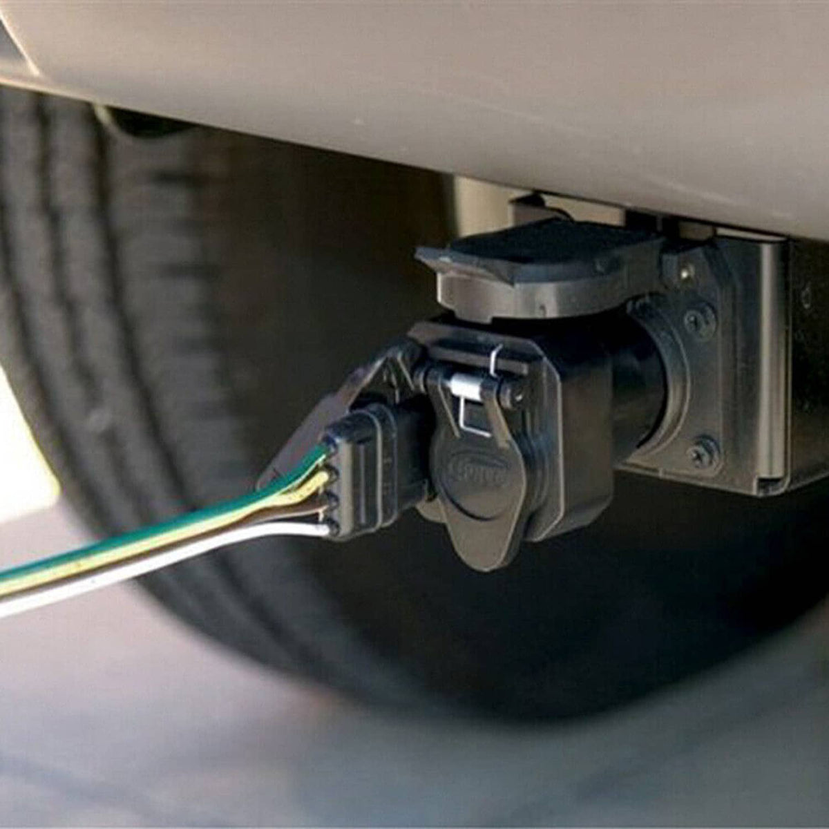 Trailer wiring connector installed under a vehicle with a multi-wire plug