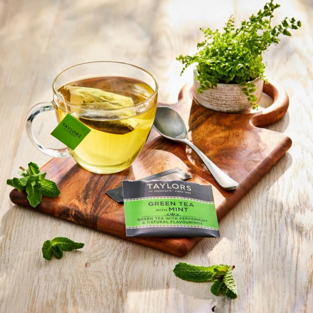 Green tea with mint tea bag box with cup of yellow tea and mint sprigs