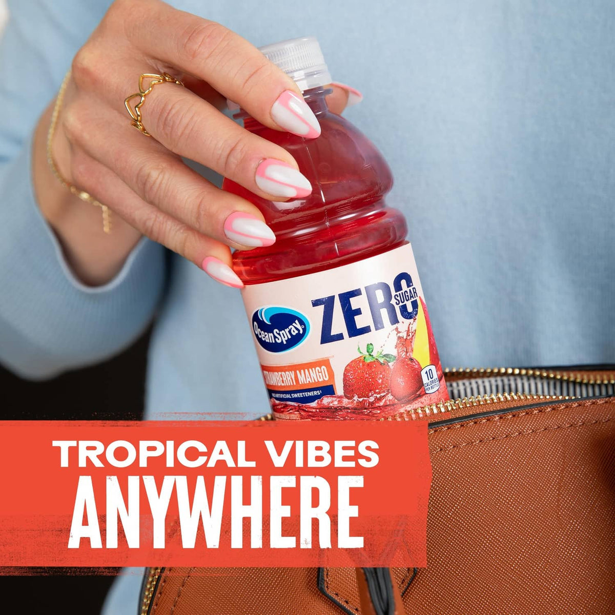 Hand holding Ocean Spray ZERO Sugar Strawberry Mango bottle with pouring drink
