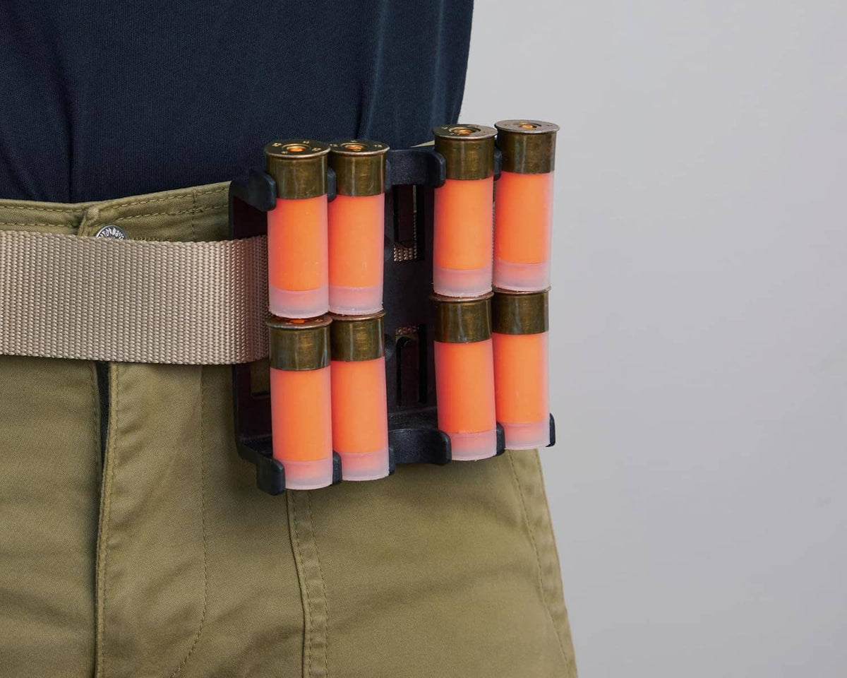 Shell speed loader mounted on a tan/olive belt with several orange shotgun shells