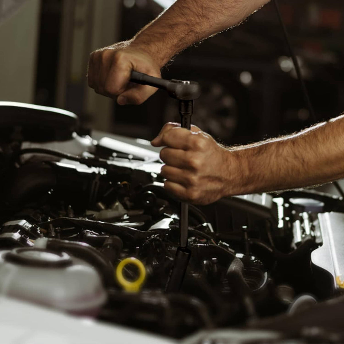 Mechanic installing a spark plug with a magnetic swivel 3/8-inch drive socket