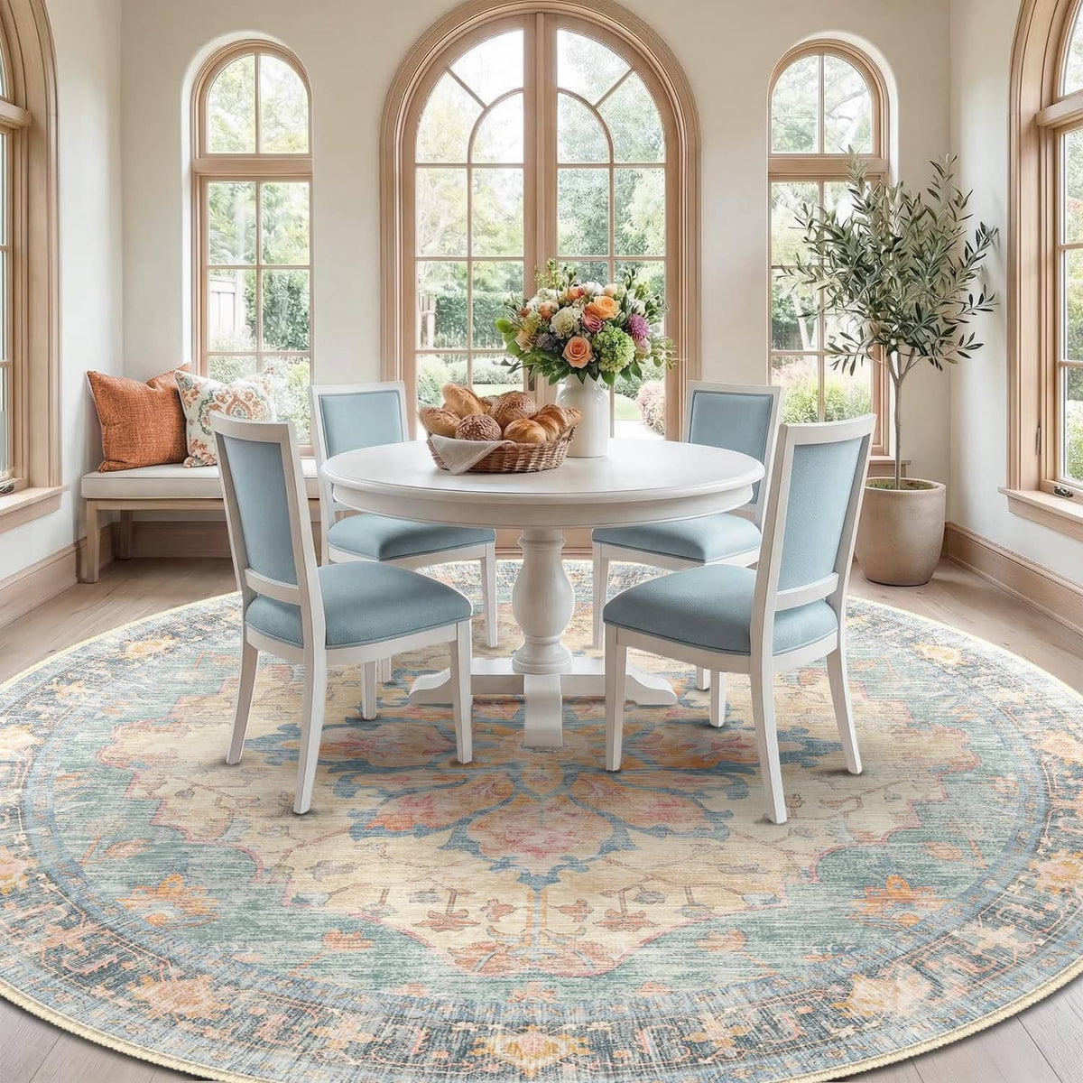 Round washable area rug with ornate blue, orange, and red pattern under dining set
