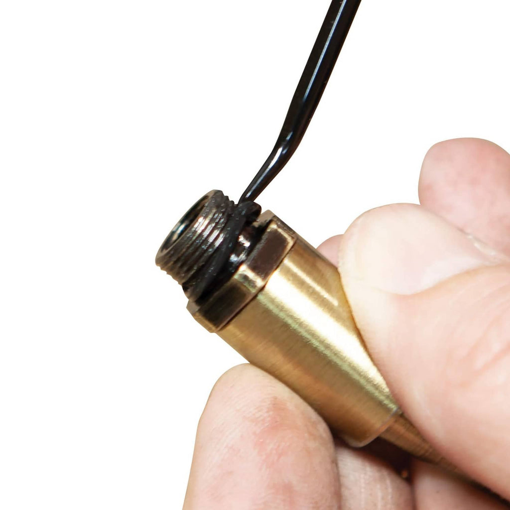 Brass threaded tip of a hook tool with black shaft, held by hand