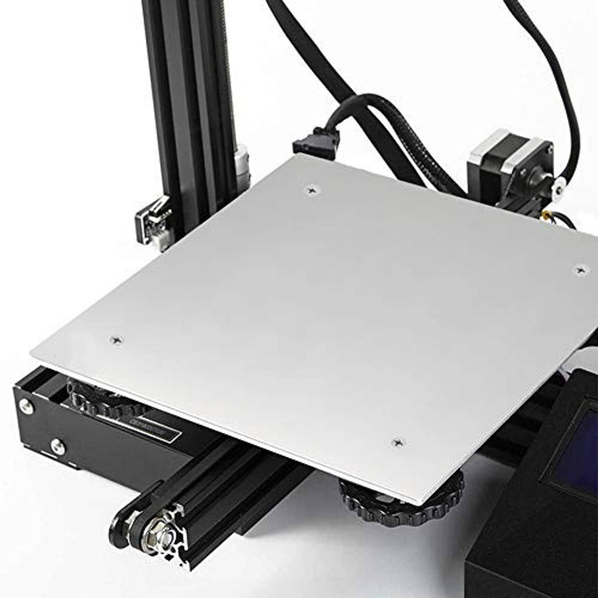 Silver heated printer bed plate mounted on printer frame with visible screws