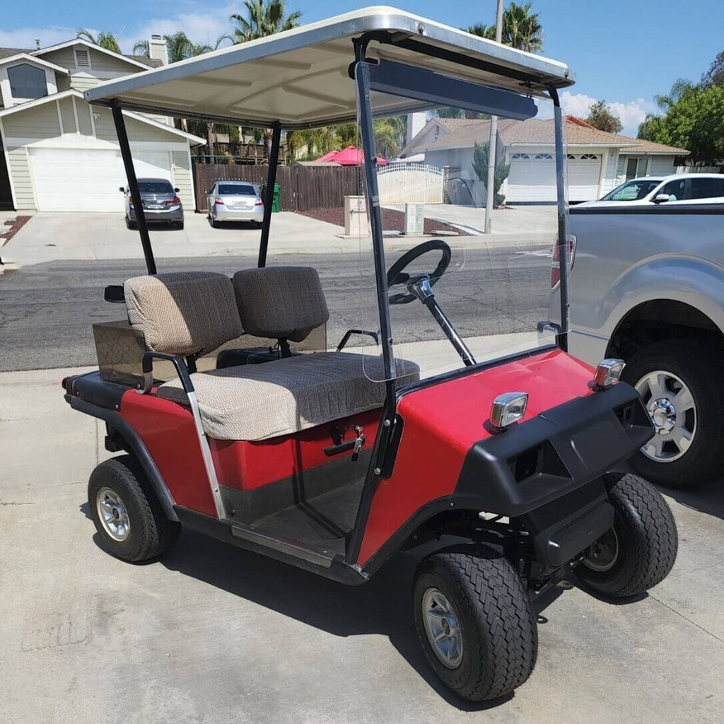 Golf cart front cowl panel with headlight openings installed on red vehicle
