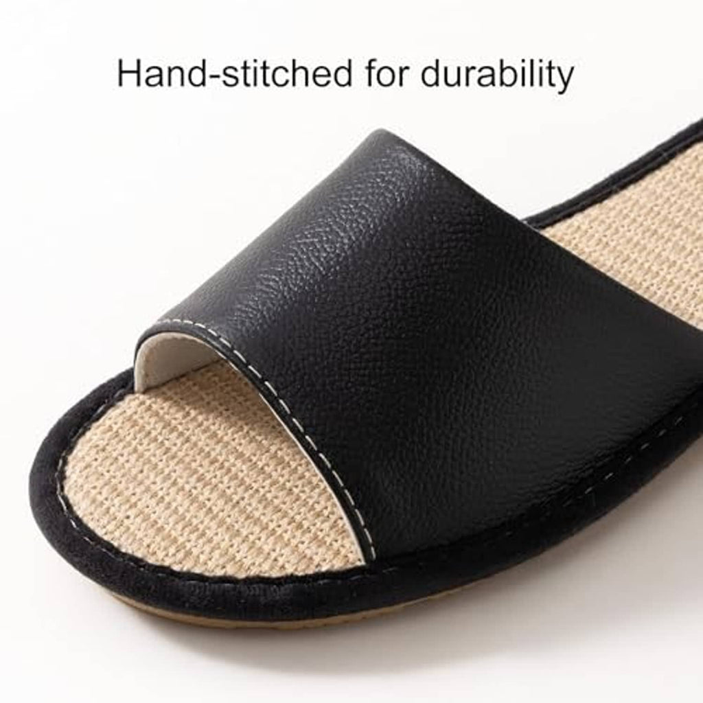 Close-up of black leather house slipper with beige woven insole and visible edge stitching.