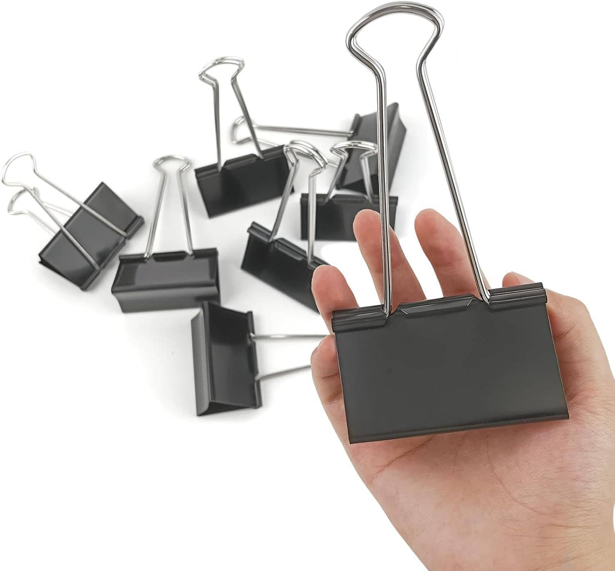 Black binder clip with metal wire handle; one clip held by hand