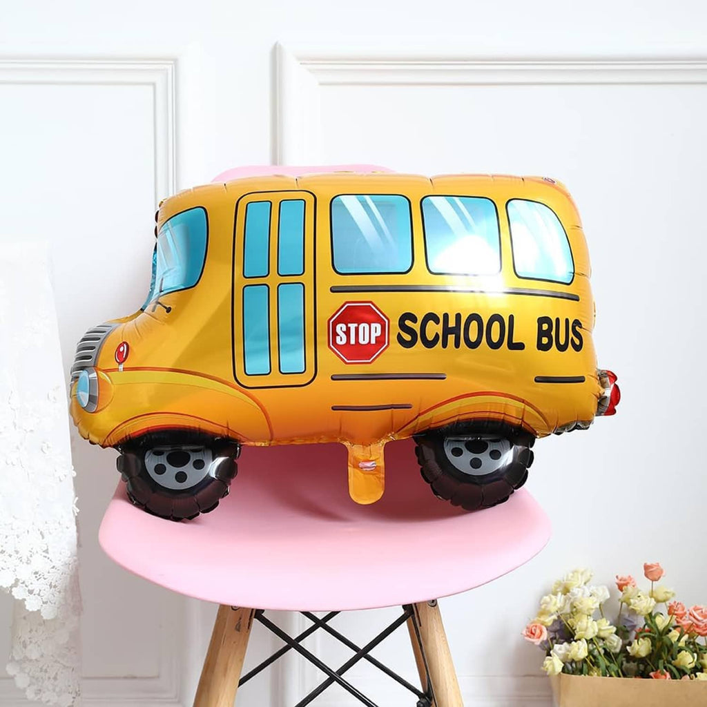 Yellow school bus balloon with blue windows, stop sign, and black wheels on round base