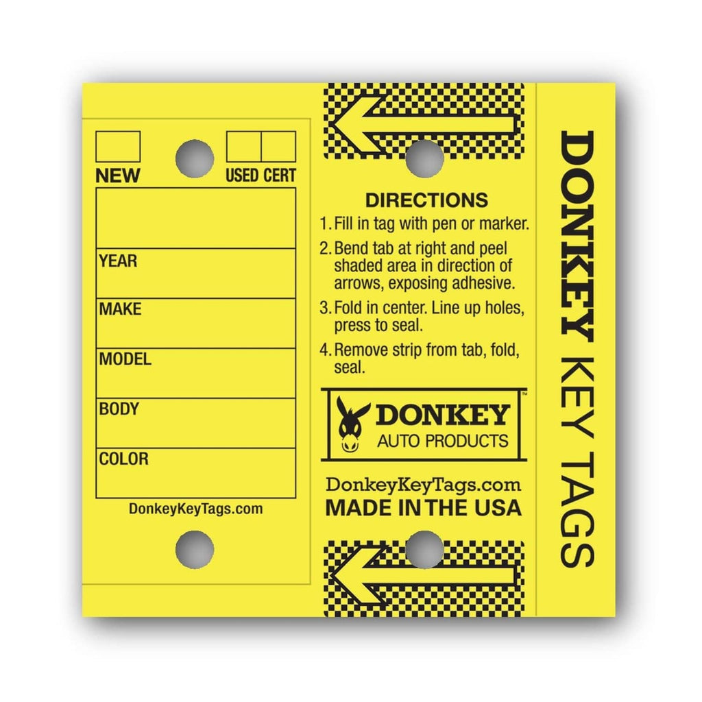 Close-up of yellow laminated key tag with directions and fields for year, make, model, color