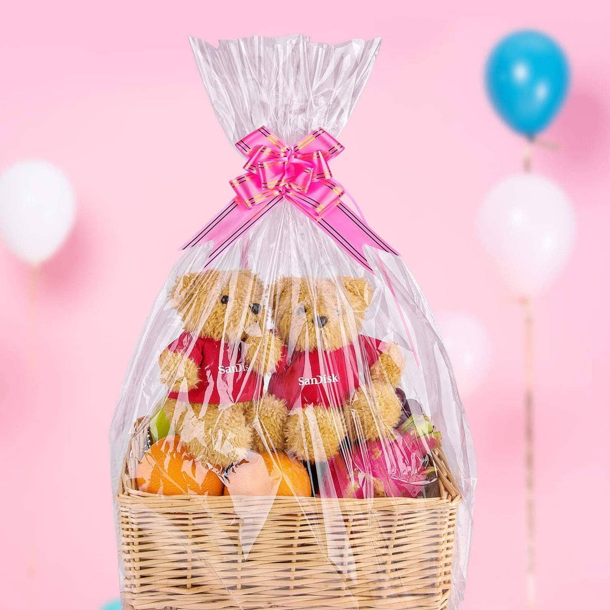 Clear cellophane basket bag with purple-pink bow, filled treats in a wicker basket.