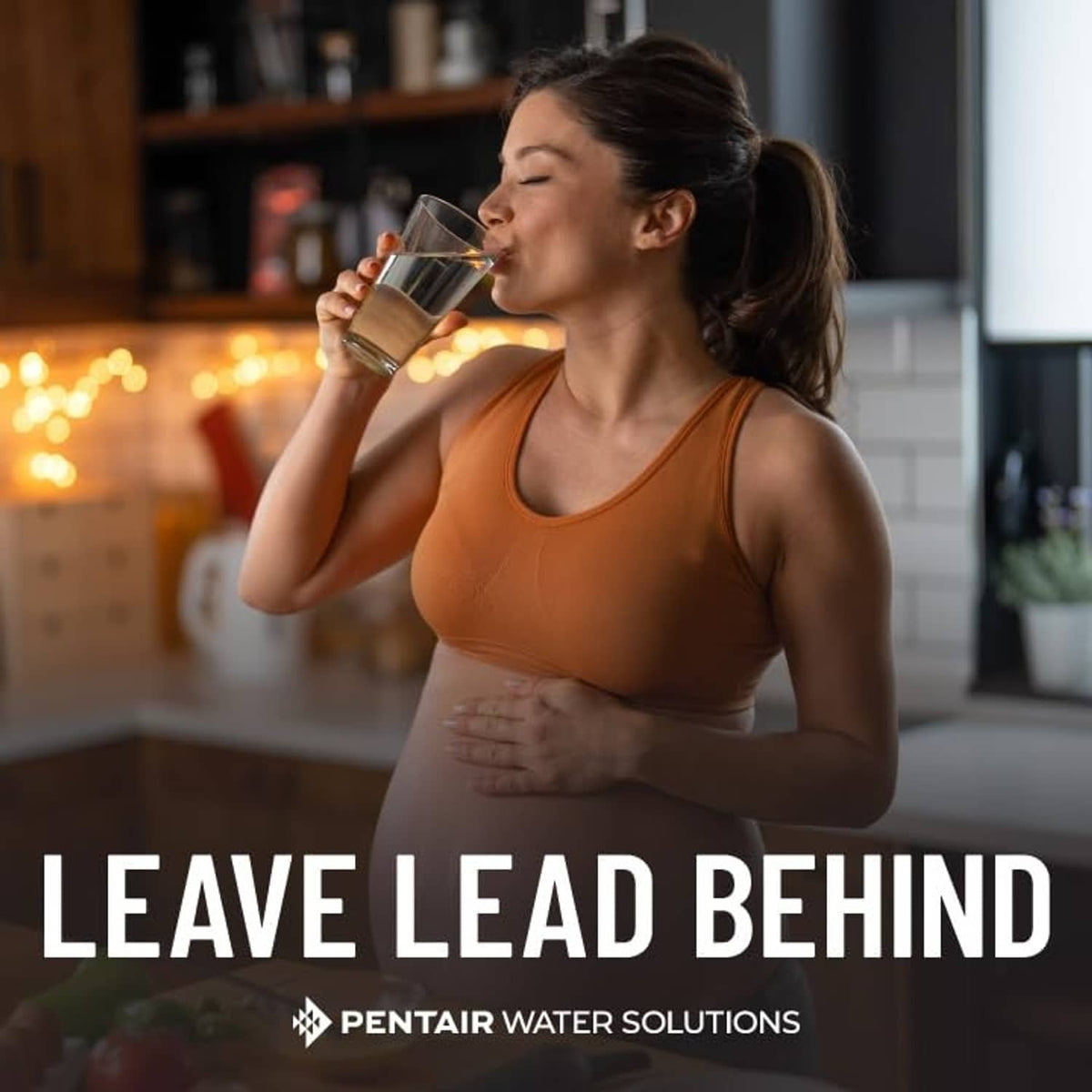 Everpure H-104 lead reduction message with person drinking water in kitchen