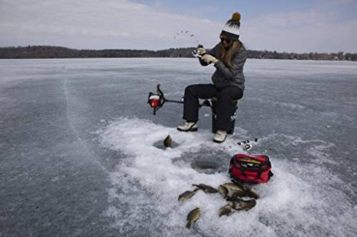 Ice fishing angler with rod, tackle, and caught fish on the ice