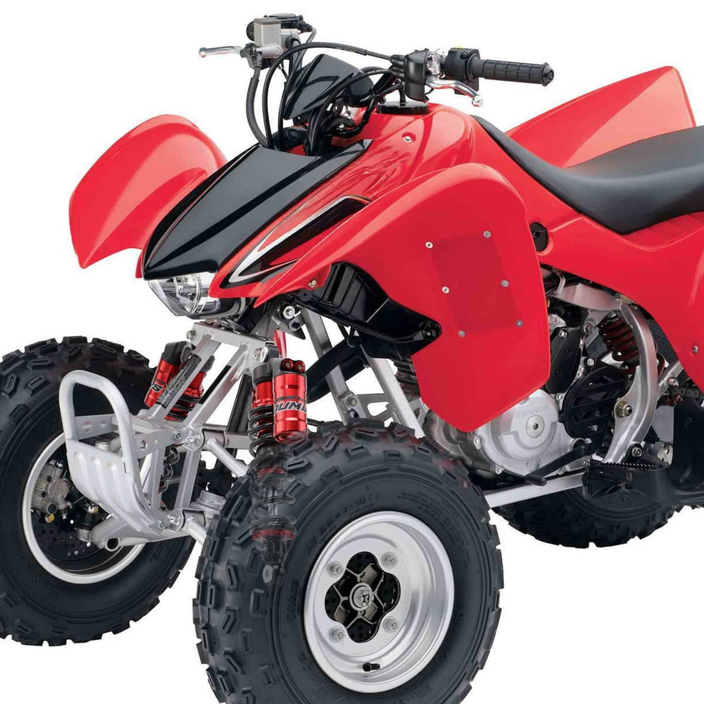 Red and black front air shock absorbers on an ATV, with coil springs and mounting bolts