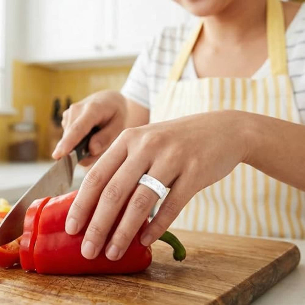 Silicone daisy ring cover on finger while chopping vegetables on a cutting board