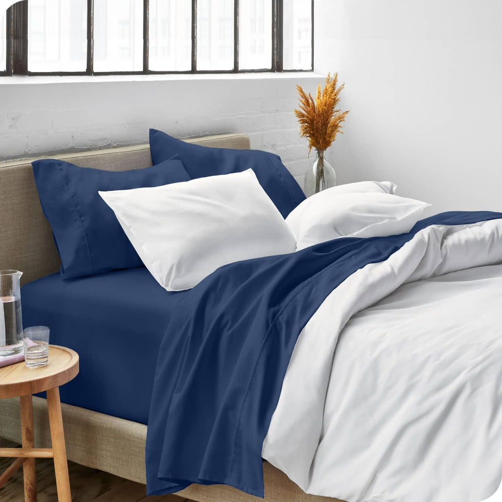 Dark blue bed sheet set with fitted sheet and pillowcases, styled with white bedding