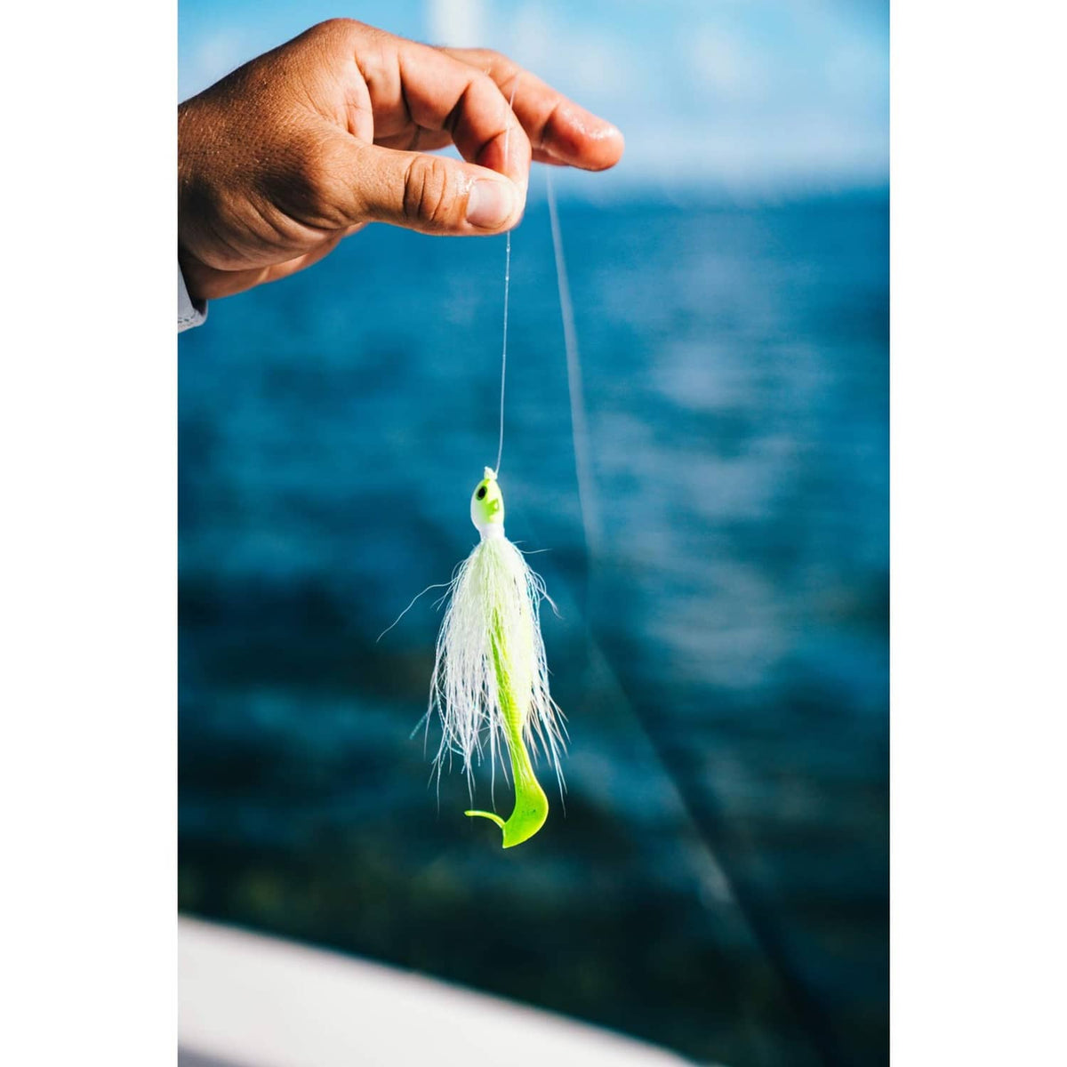 Fishing lure with chartreuse head and white feathered skirt