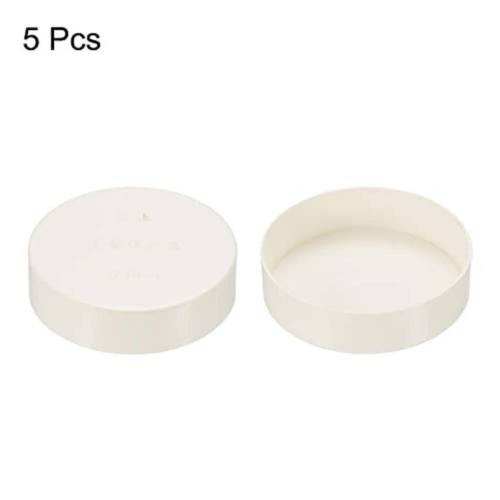 Two white PVC pipe end cap fittings, round tops with open cup interior