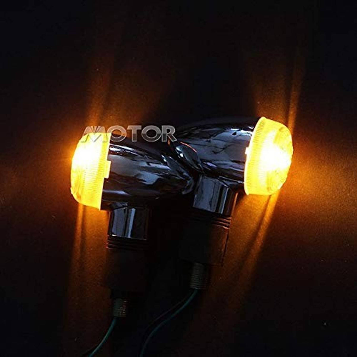 Pair of motorcycle turn signal lights illuminated with amber glow, chrome and black housings